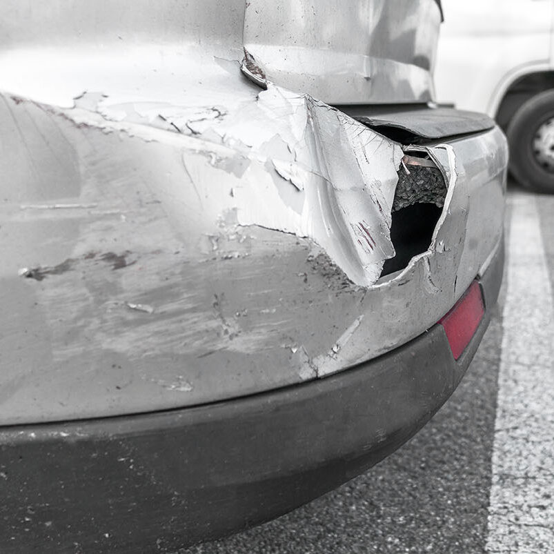 Back of gray car get damaged from accident on the road. Vehicle bumper dent  broken by car crash. Road accidents.